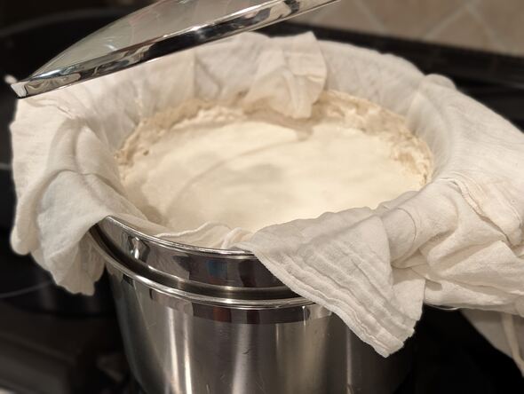 Straining with a cheese cloth in a colander pot to make Greek yogurt. 