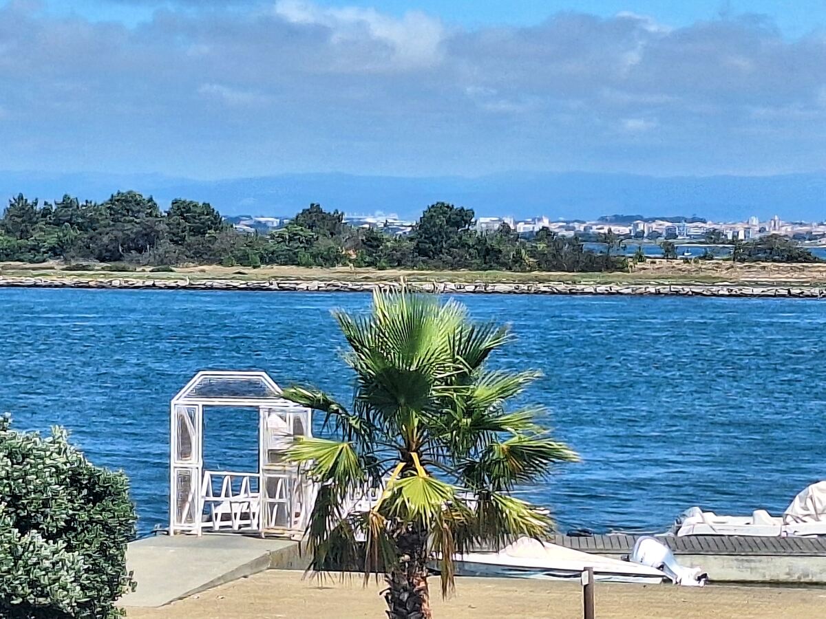 The photo shows the Ria de Aveiro lagoon (with downtown Aveiro in the background) on a sunny and windy day