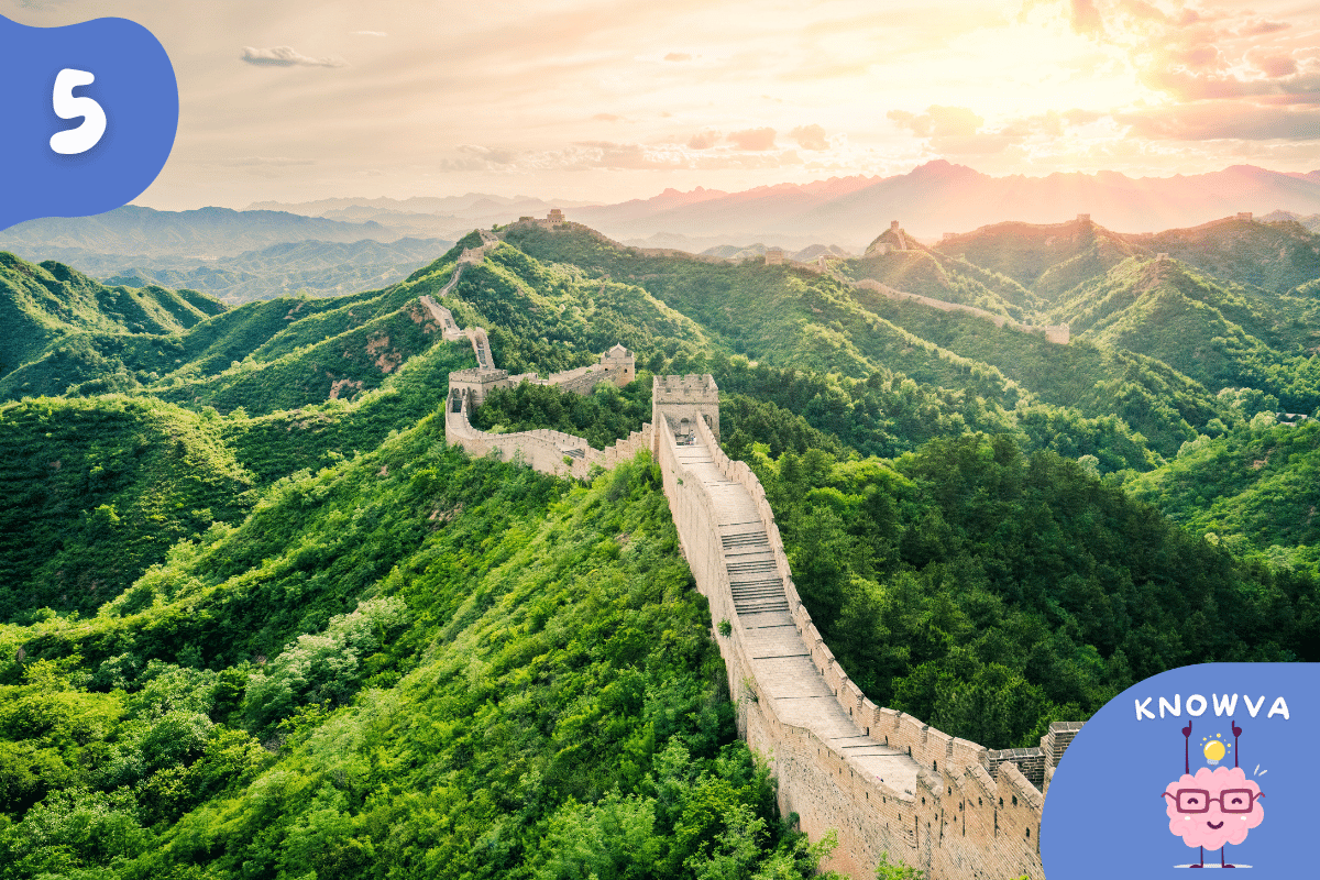 The Great Wall of China stretching out over green hills.
