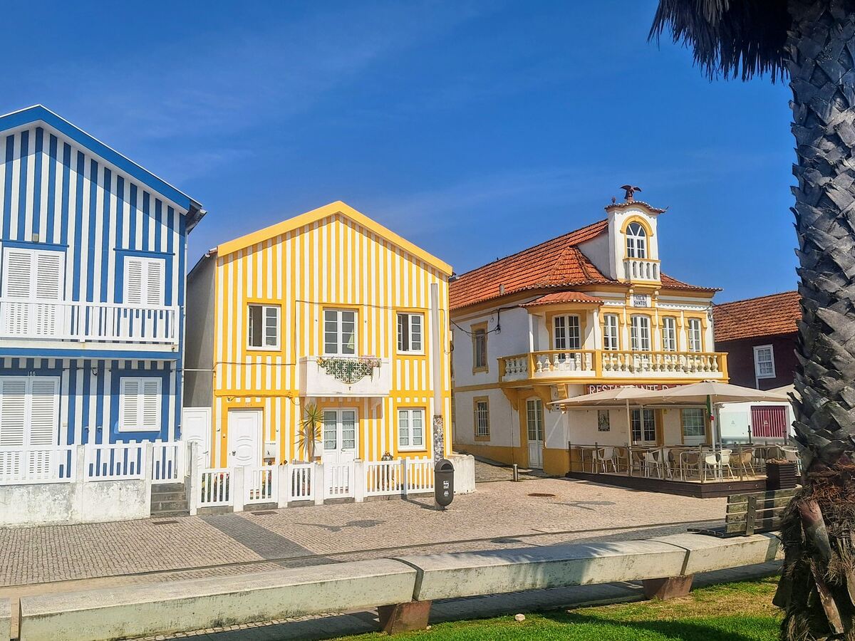 The photo shows typical colorful houses in Costa Nova, Aveiro district, in Portugal, on a morning in July 2026.