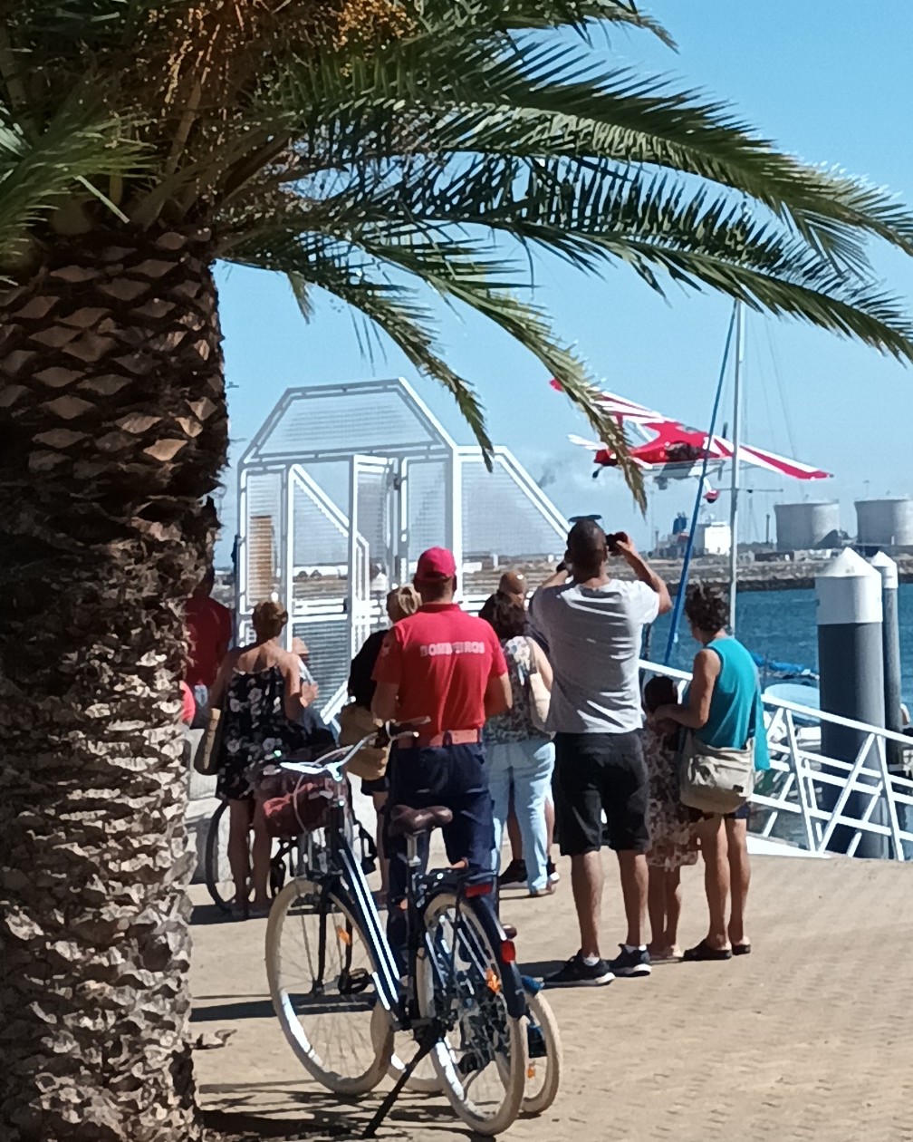 The photo shows five onlookers at an off-shore aerobatic fly-by at the Dunas Festival airshow in São Jacinto, Aveiro, Portugal in 2023.