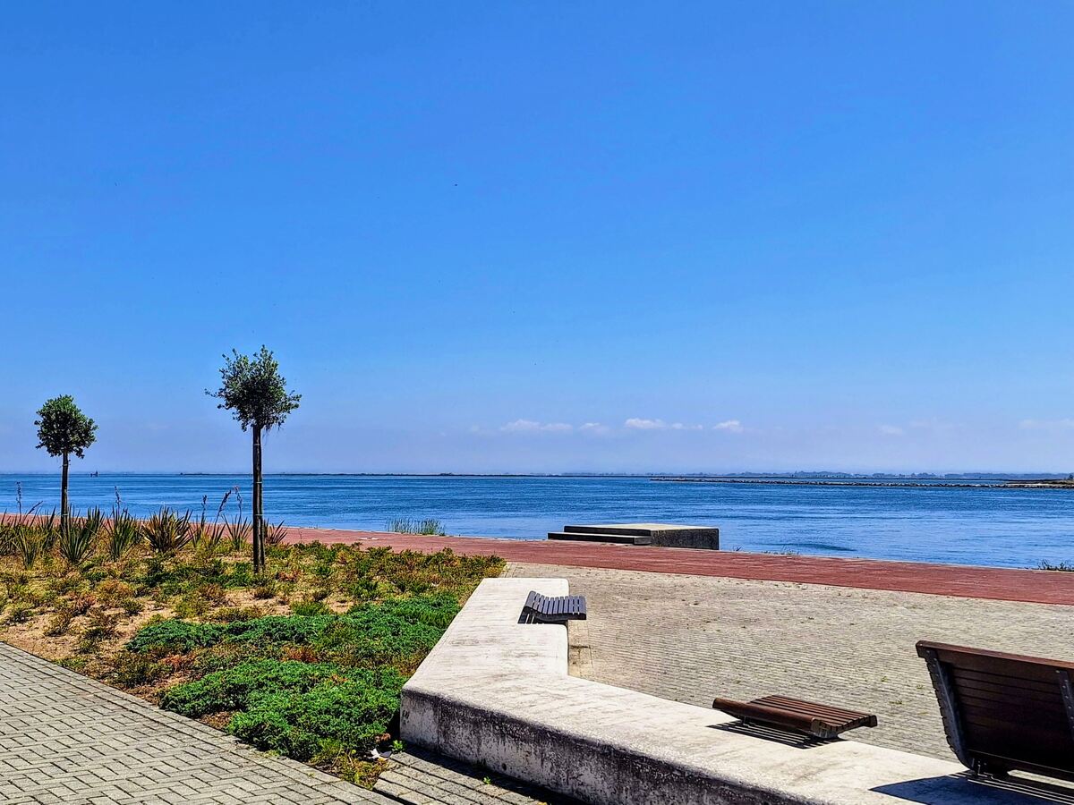 The photo shows the view from a sitting area on the Ria de Aveiro promenade in São Jacinto, Aveiro